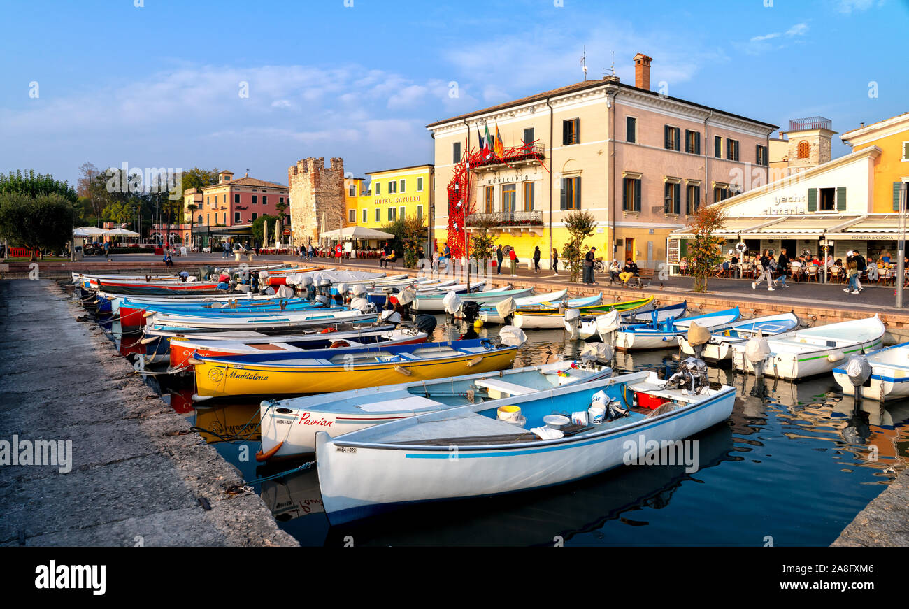 Bardolino, Italie, 10/28/2019 - Bateaux dans le port de la vieille ville de Bardolino et balades et les touristes assis dans les restaurants. La ville est une desti Banque D'Images