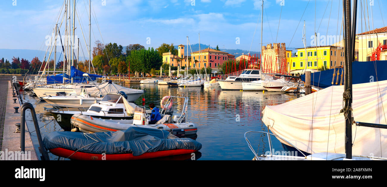 Bardolino, Italie, 10/28/2019 - Bateaux dans le port de la vieille ville de Bardolino et balades et les touristes assis dans les restaurants. La ville est une desti Banque D'Images