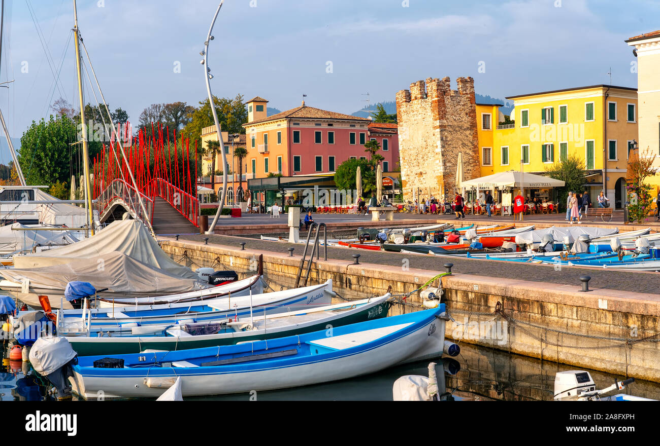 Bardolino, Italie, 10/28/2019 - Bateaux dans le port de la vieille ville de Bardolino et balades et les touristes assis dans les restaurants. La ville est une desti Banque D'Images