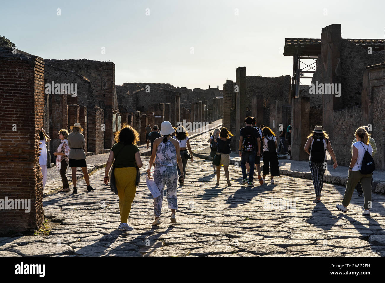 Syndicat parmi les ruines de Pompéi se promener au coucher du soleil sur la Via dell'abbondanza. Pompéi, Italie, Octobre 2019 Banque D'Images