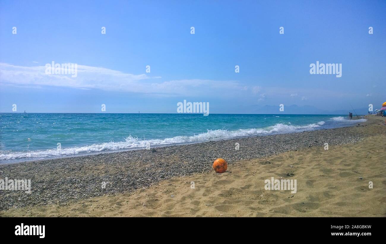 Balle orange à la plage de sable près de la mer et bleu ciel bleu clair. L'Italie du Sud Banque D'Images
