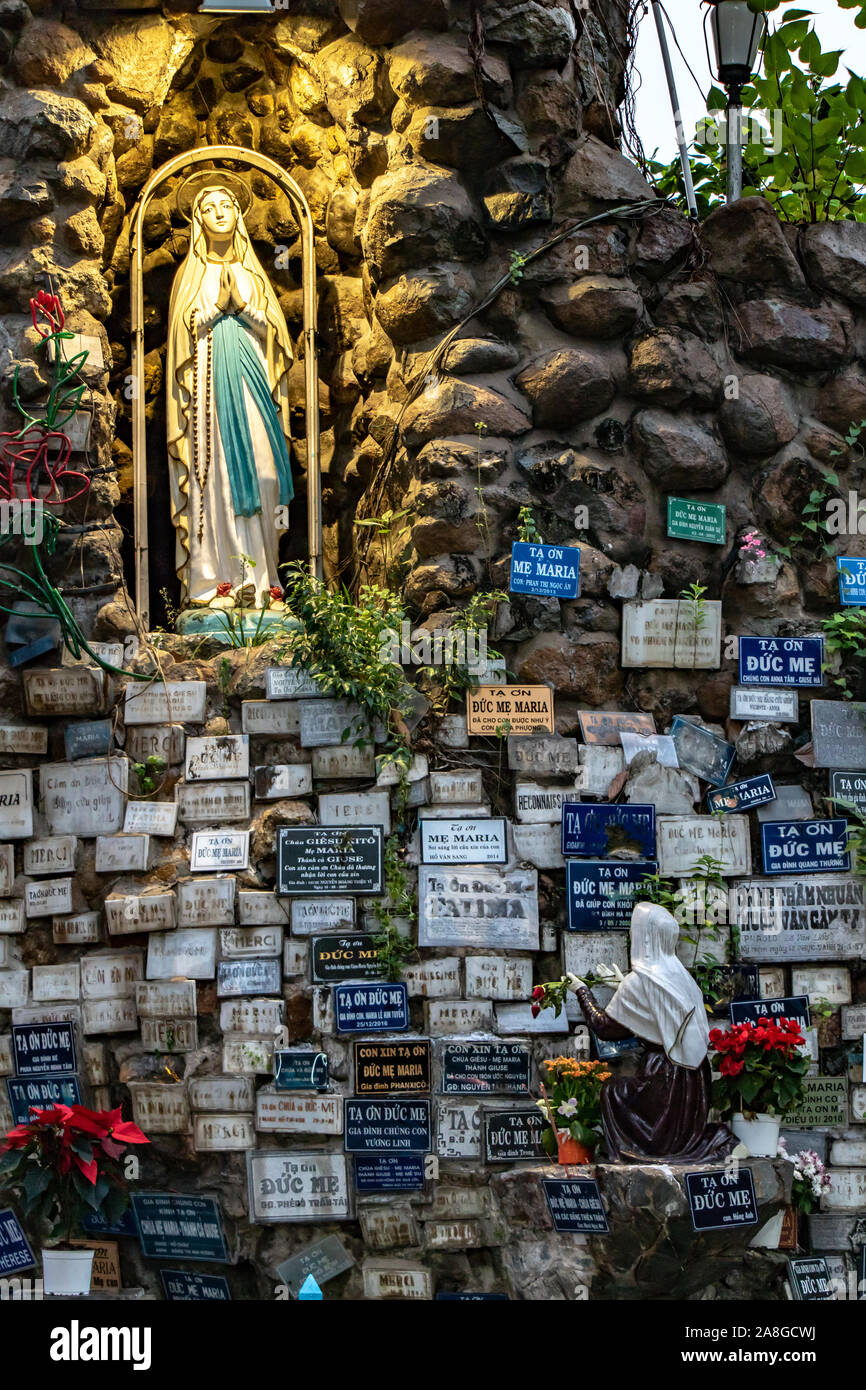 SAIGON, Vietnam, 18 déc 2017, illuminée statue de Vierge Marie dans la populaire place la prière Ave Maria avec mur de pierre plein de pancarte, église l'Huy Banque D'Images