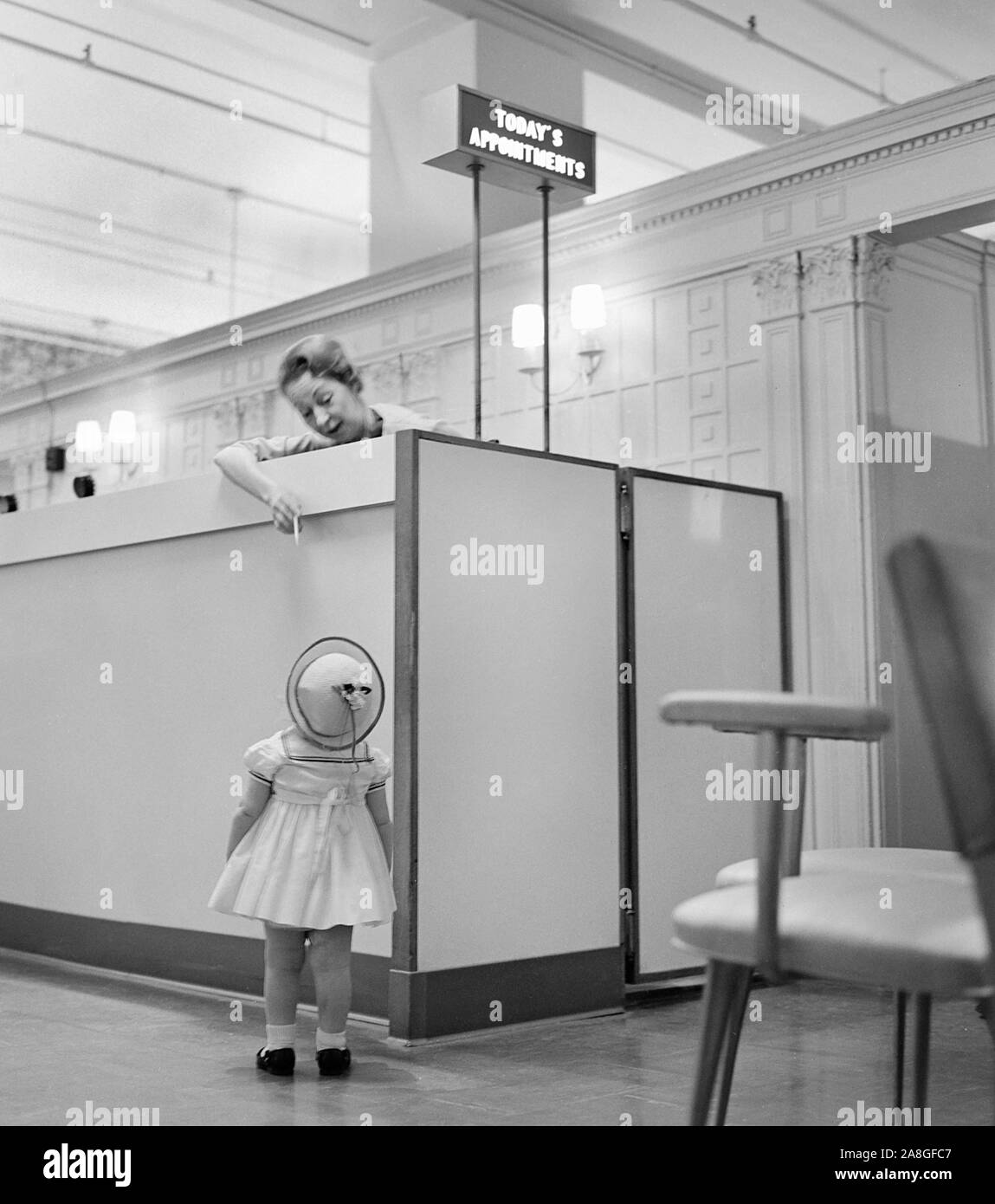 Une jeune personne ayant une hauteur et attend son tour pour un rendez-vous, ca. 1962. Banque D'Images