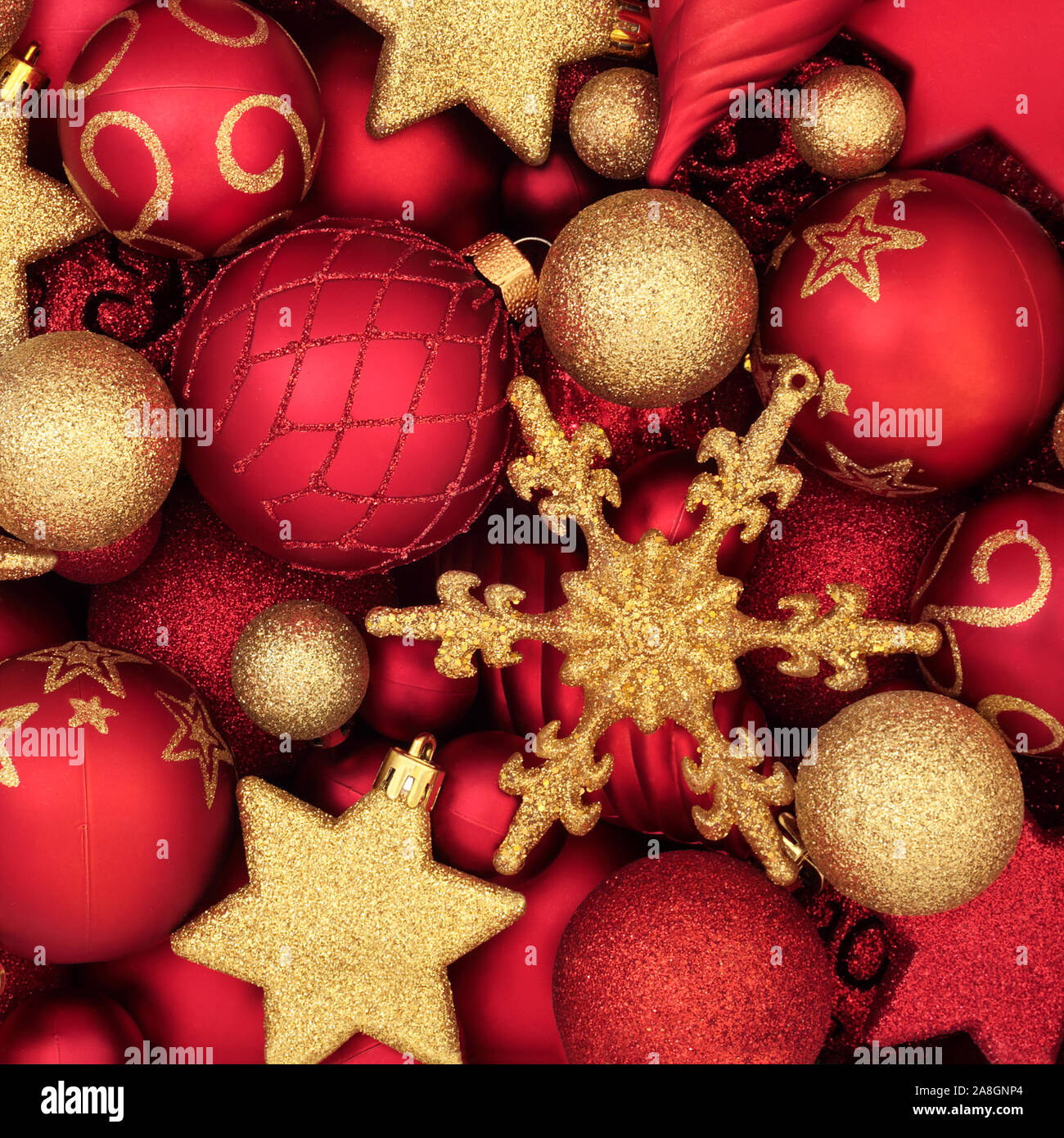 Le rouge et l'or de décorations de Noël formant un motif de fond. Symboles traditionnels pour les fêtes. Banque D'Images