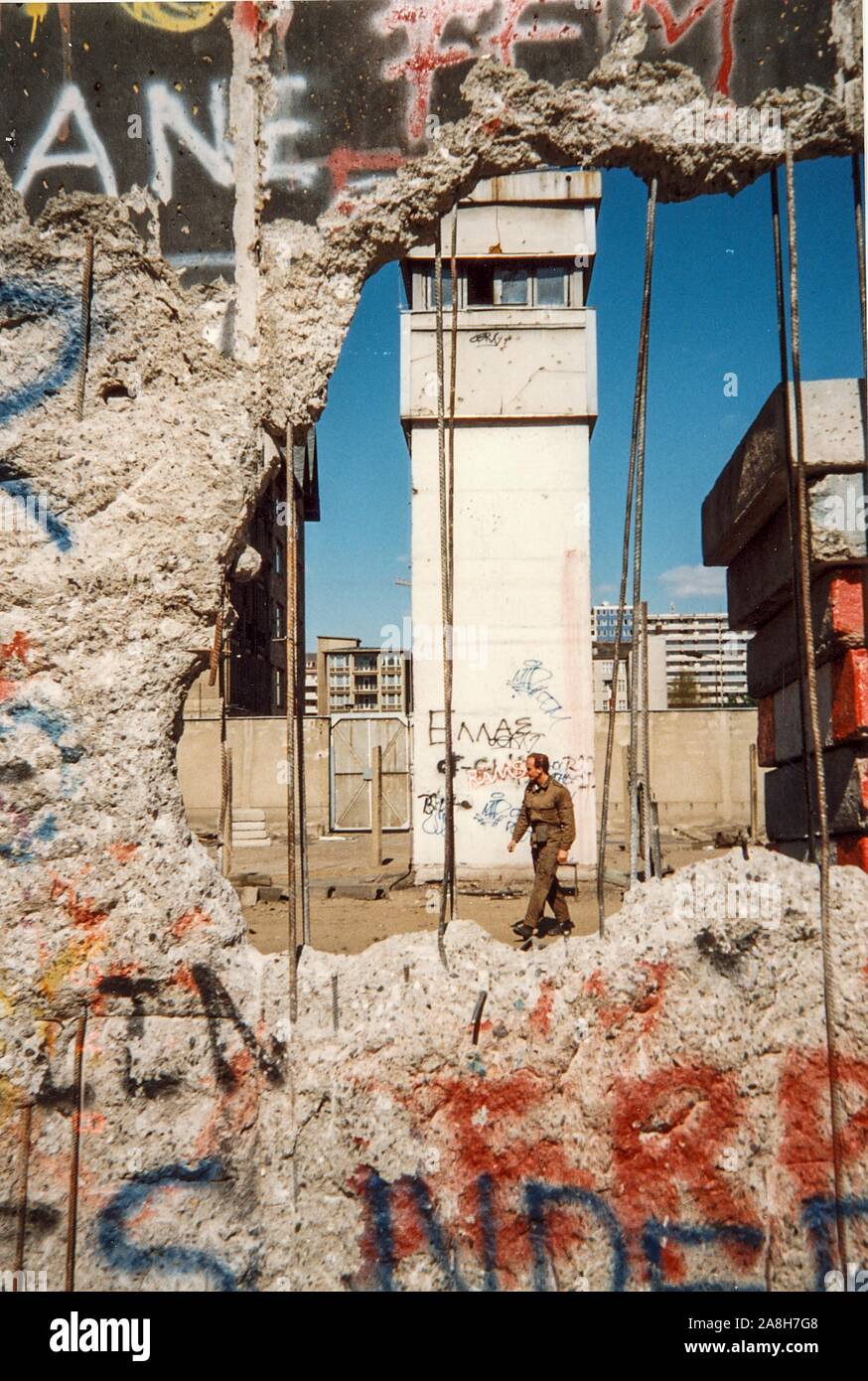 Michael Scott/Alamy Live News - Berlin, Allemagne, avril 1990 - Un soldat allemand passe devant une tour de garde à Berlin, photographié par un trou dans le mur de Berlin en avril 1990 mois après la chute du Mur de Berlin en 1989. Banque D'Images