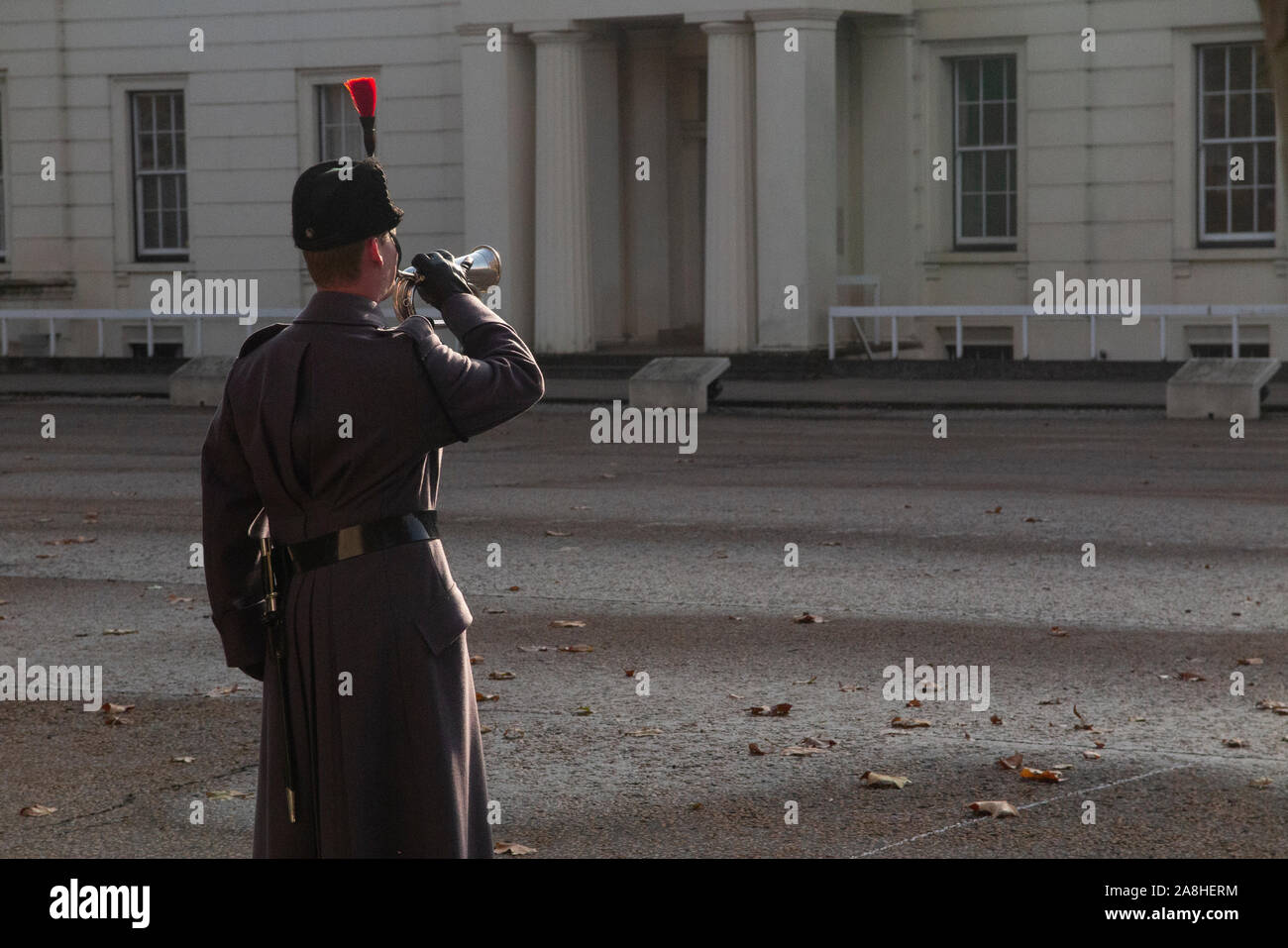 Un soldat dans un grand manteau joue le bugle en novembre pour le Jour du Souvenir Banque D'Images