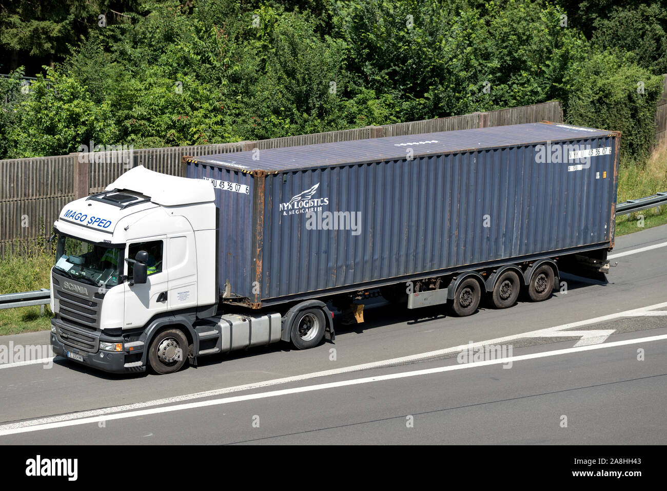 Mago Sped Scania camion avec NYK récipient sur autoroute. Banque D'Images