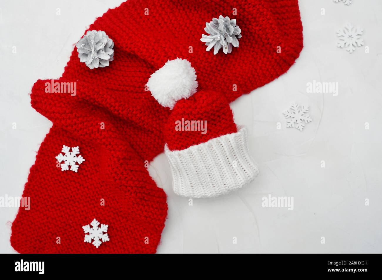 Santa red hat et foulard rouge sur fond de bois avec place pour votre texte. Noël arrière-plan avec les cônes et les flocons Banque D'Images