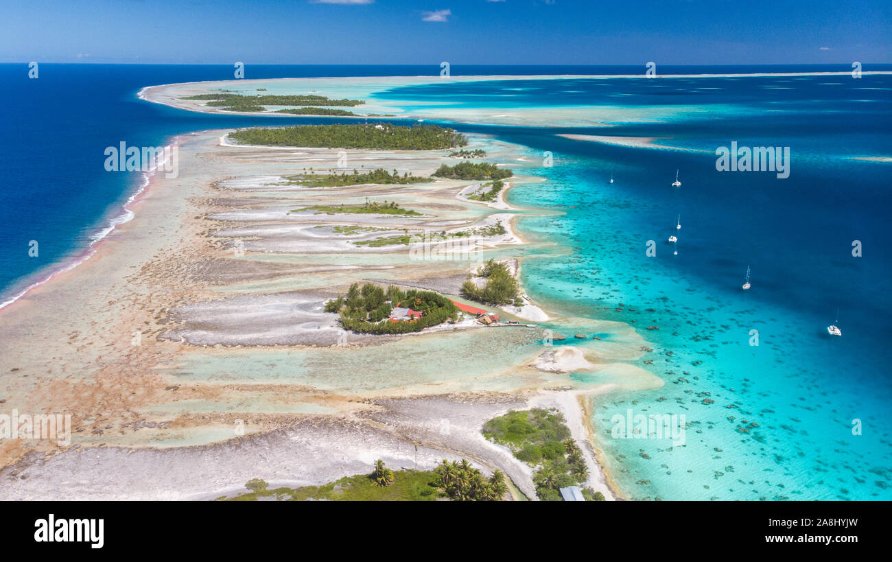 Catamaran à voile avec archipel des Tuamotu en Polynésie française - vue aérienne de la lagune par drone Banque D'Images