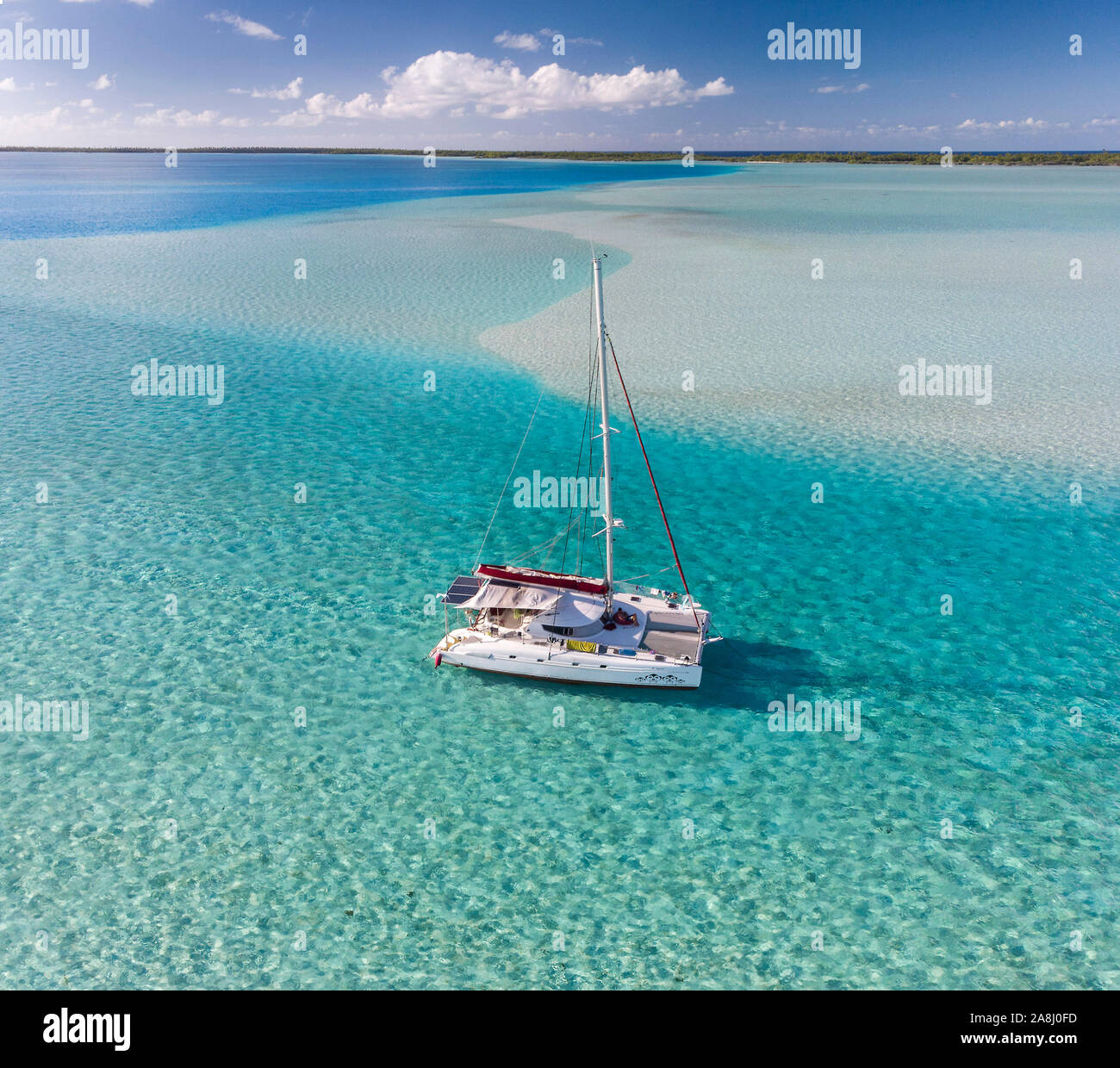 Catamaran à voile avec archipel des Tuamotu en Polynésie française - vue aérienne de la lagune par drone Banque D'Images