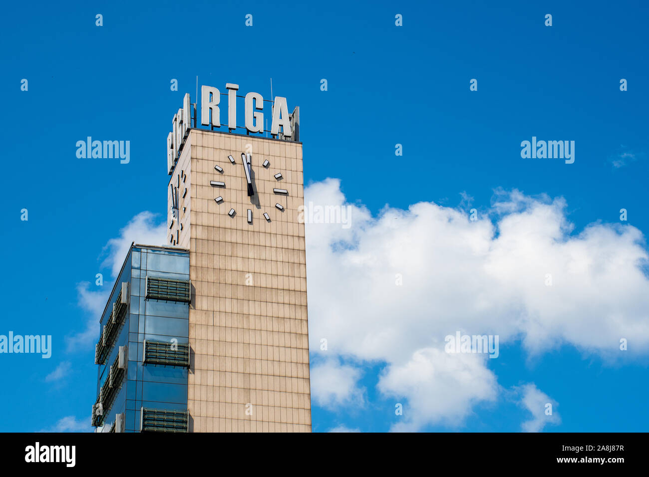 La gare centrale de Riga tour avec nom de la ville et de l'horloge, ciel bleu en arrière-plan Banque D'Images