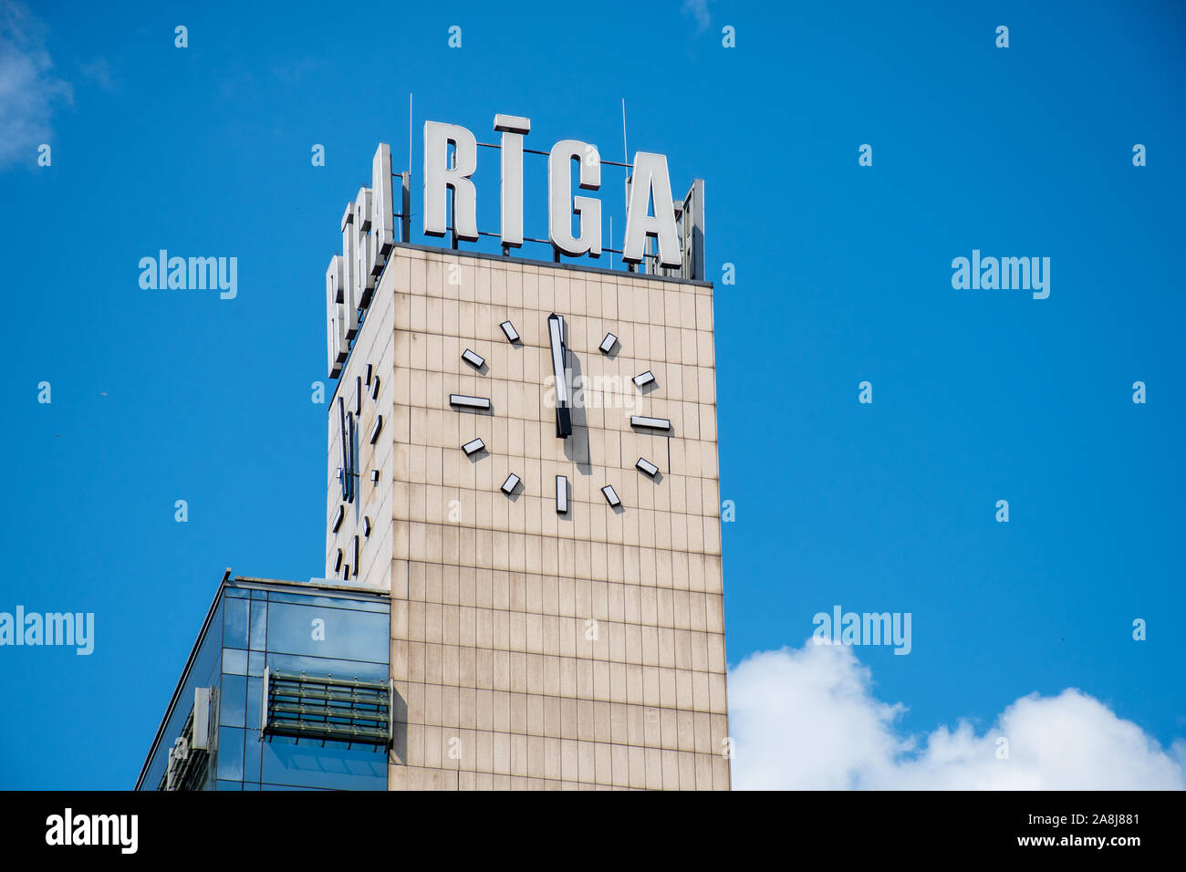 La gare centrale de Riga tour avec nom de la ville et de l'horloge, ciel bleu en arrière-plan Banque D'Images