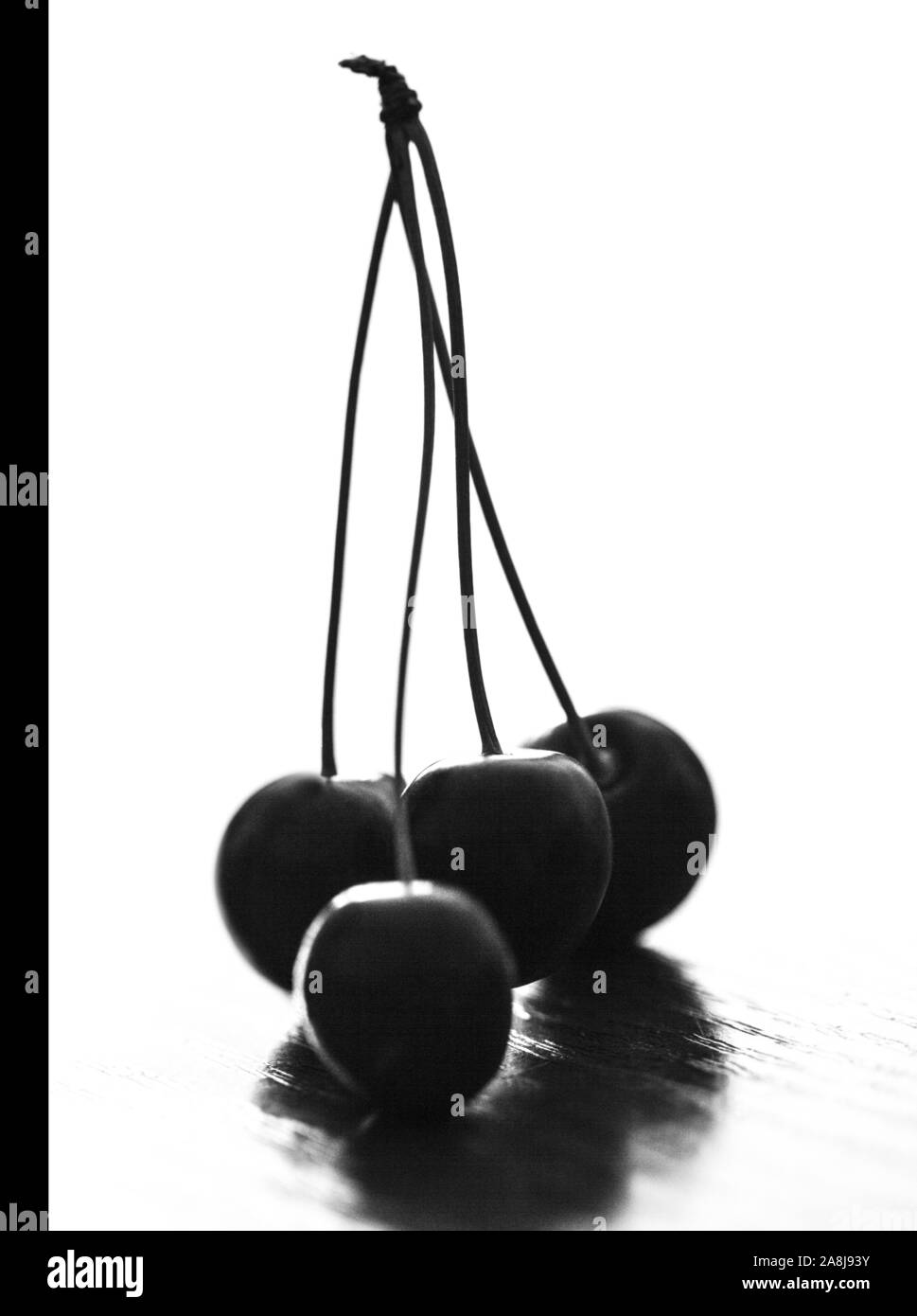 Cerises juteuses sur la surface de la table, noir et blanc. Banque D'Images