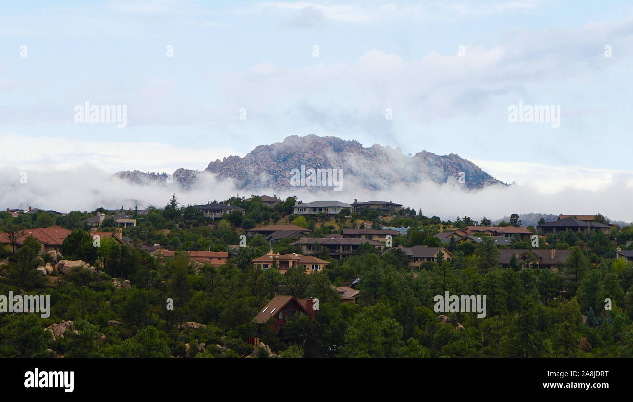 La montagne de granit vêtu de bas nuages brumeux comme matin vient d'Arizona du Nord. Banque D'Images
