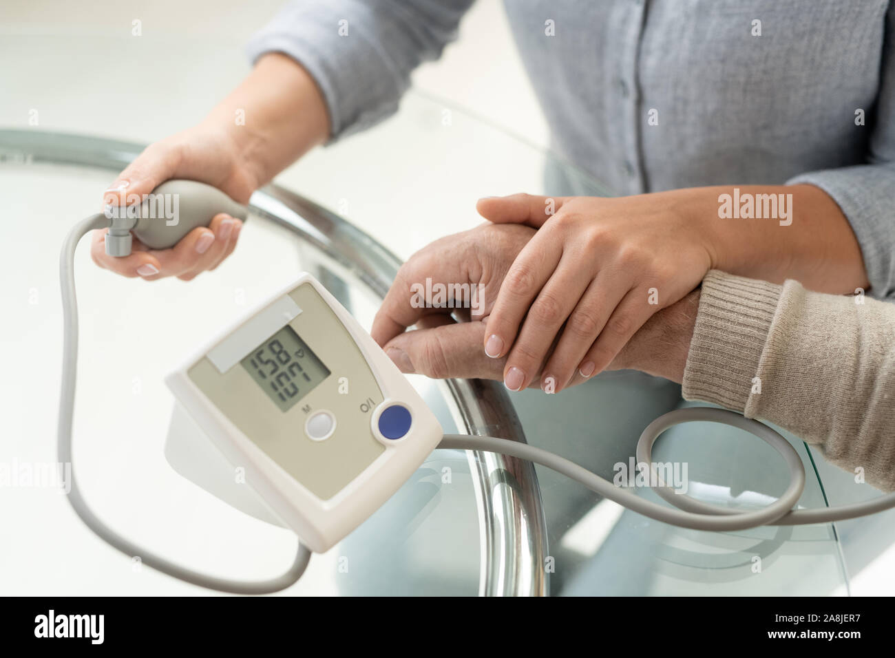 Main de jeune femme à celui de son premier père malade au cours de l'aide médicale Banque D'Images
