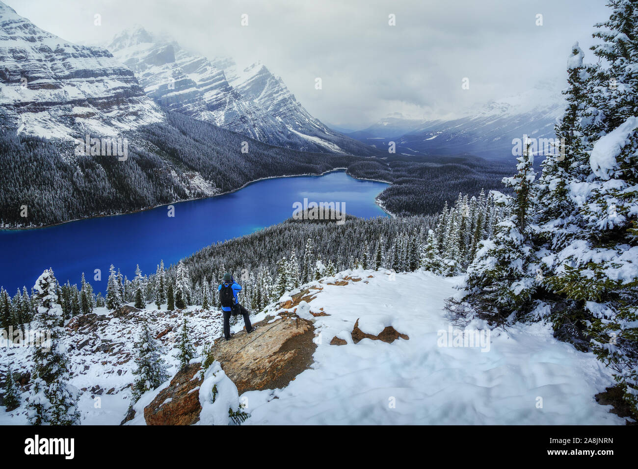 Photographe à Peyto Lake, Canadian Rockies, montagnes Rocheuses, au Canada. Neige et ciel nuageux. Les eaux bleu. Aventurier. Banque D'Images