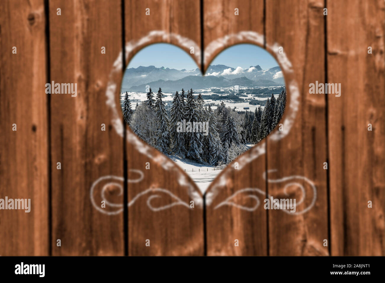 À l'intermédiaire d'un coeur en bois sculpté dans un mur de neige magnifique paysage couvert Banque D'Images