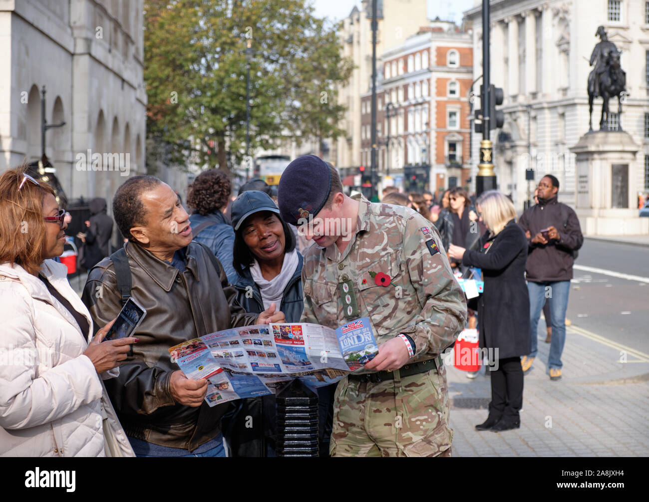 L'homme militaire sur la rue de Londres, aider trouver les indications touristiques sur une carte en face de Whitehall Banque D'Images