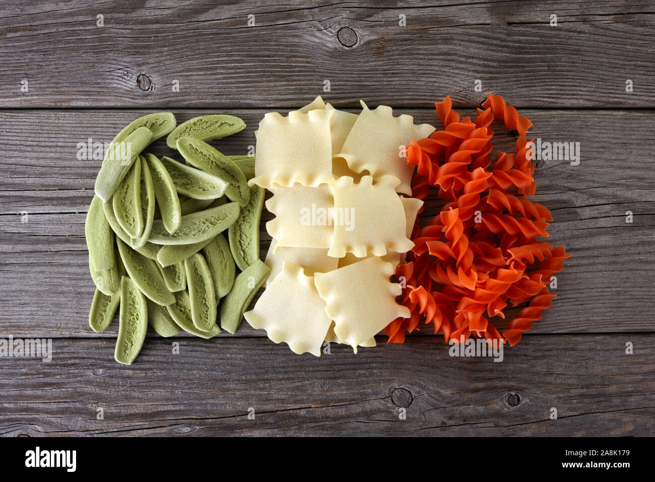 Spaghetti séchés dans les couleurs du drapeau italien sur fond de bois Banque D'Images