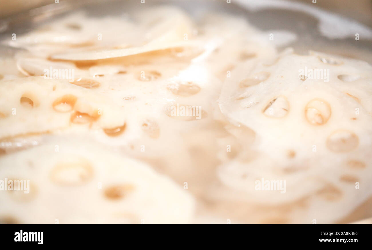 Tranches de racines de lotus frais être bouilli en pot - ingrédients asiatiques (isolé) - Image Banque D'Images