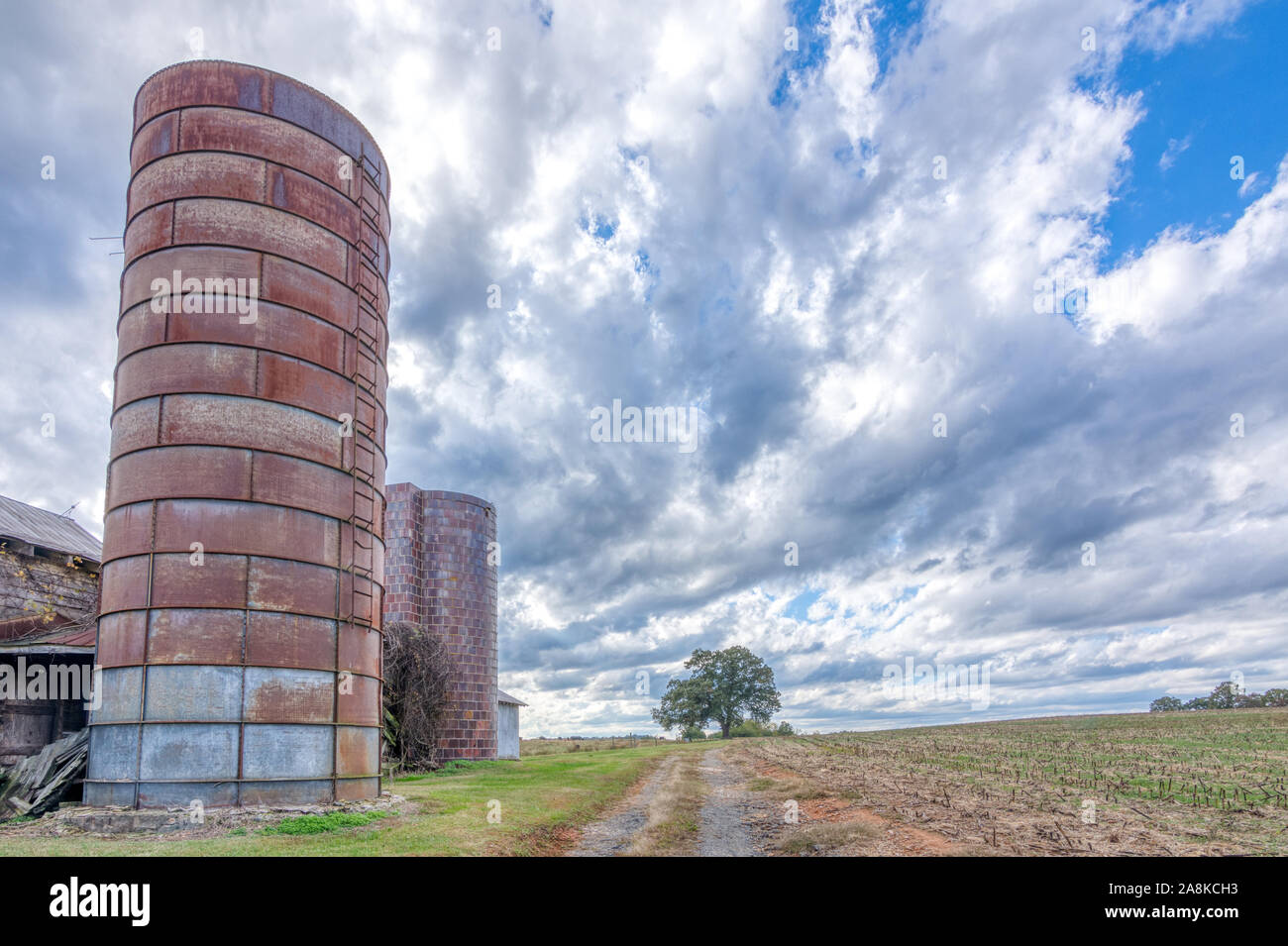 Grange abandonnée avec silo sous les nuages orageux dans Alamance County North Carolina Banque D'Images