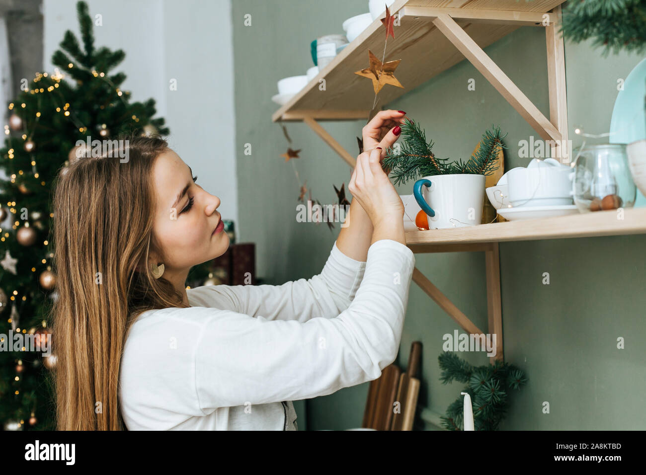Belle femme décore un appartement pour Noël Banque D'Images
