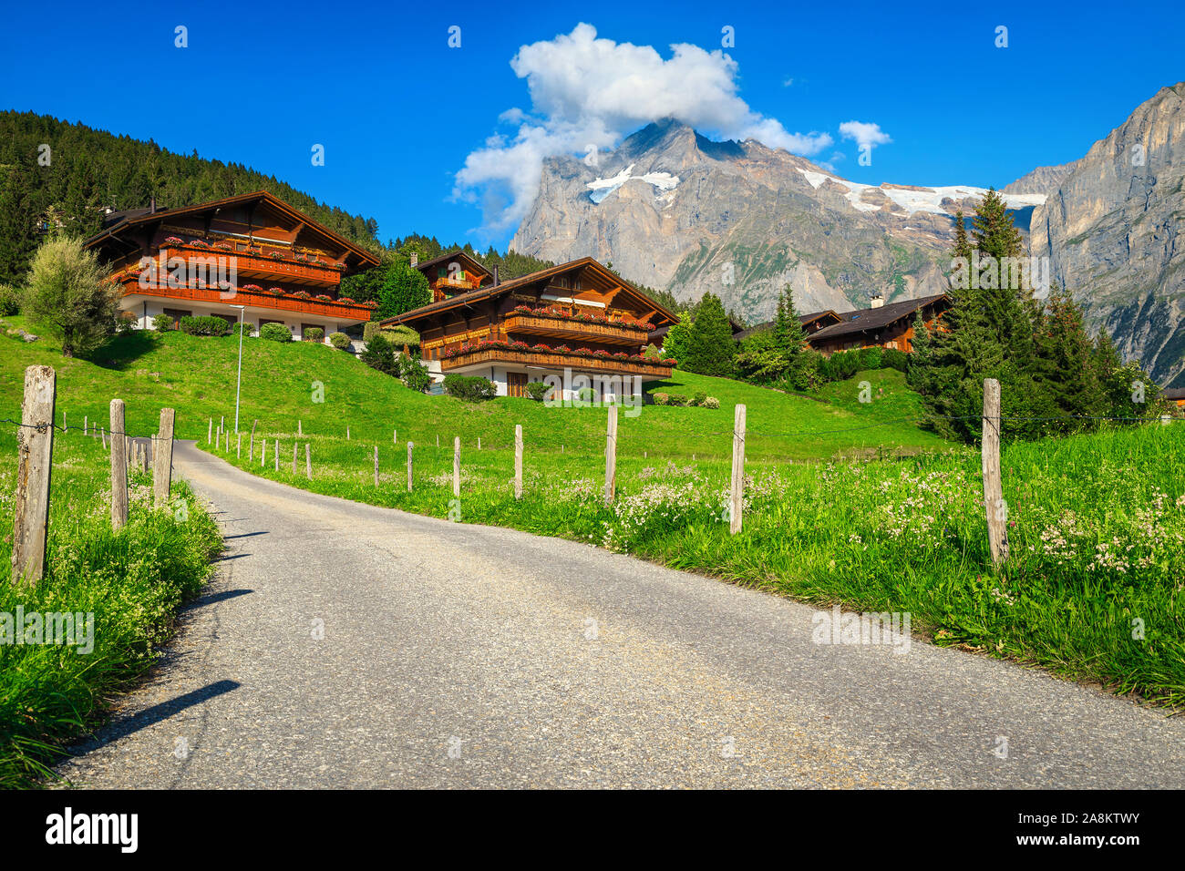Amazing mountain resort alpine traditionnelle avec des maisons en bois et de hautes montagnes enneigées en arrière-plan, Grindelwald, Oberland Bernois, Suisse, Euro Banque D'Images