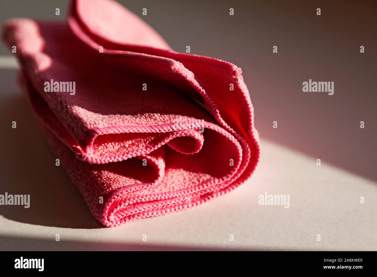 Un chiffon non tissé rose couché dans la fenêtre que le soleil se couche Banque D'Images