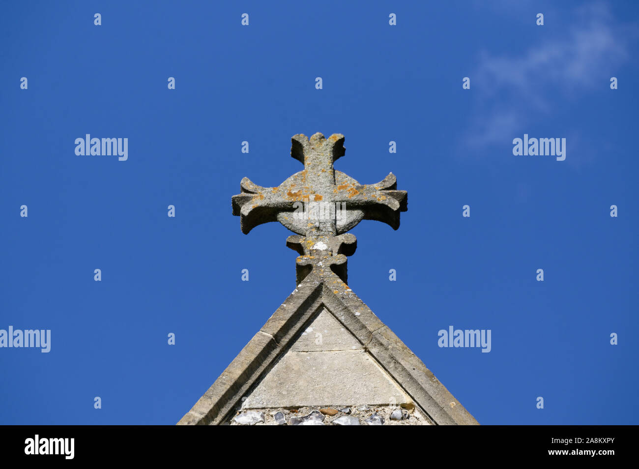 Une croix se trouve au sommet d'une église contre un ciel bleu Banque D'Images