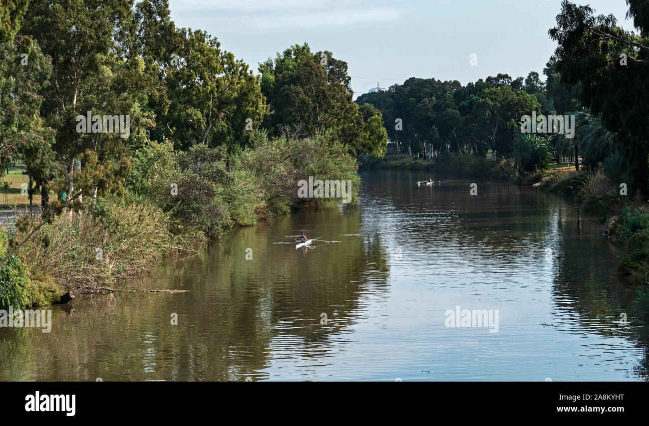 Deux rameurs pratiquer sur la rivière bordée d'arbres dans le parc yarkon à Tel Aviv, dans une journée d'automne ensoleillée Banque D'Images