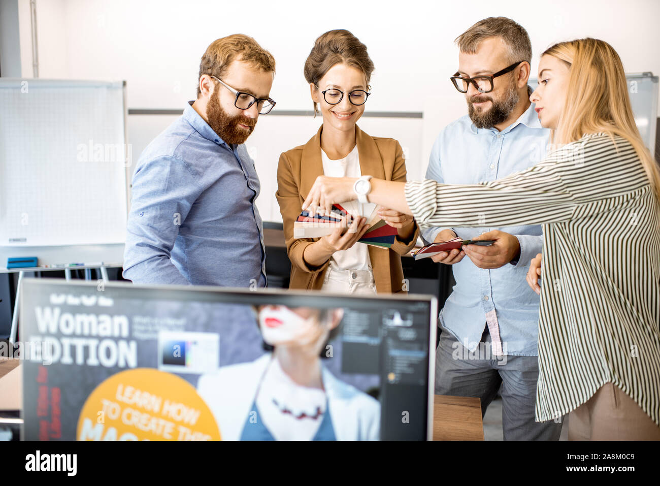 Groupe de gens créatifs variés ayant une petite discussion, travaillant comme un des concepteurs de sites web dans les bureaux modernes ou espace de coworking Banque D'Images