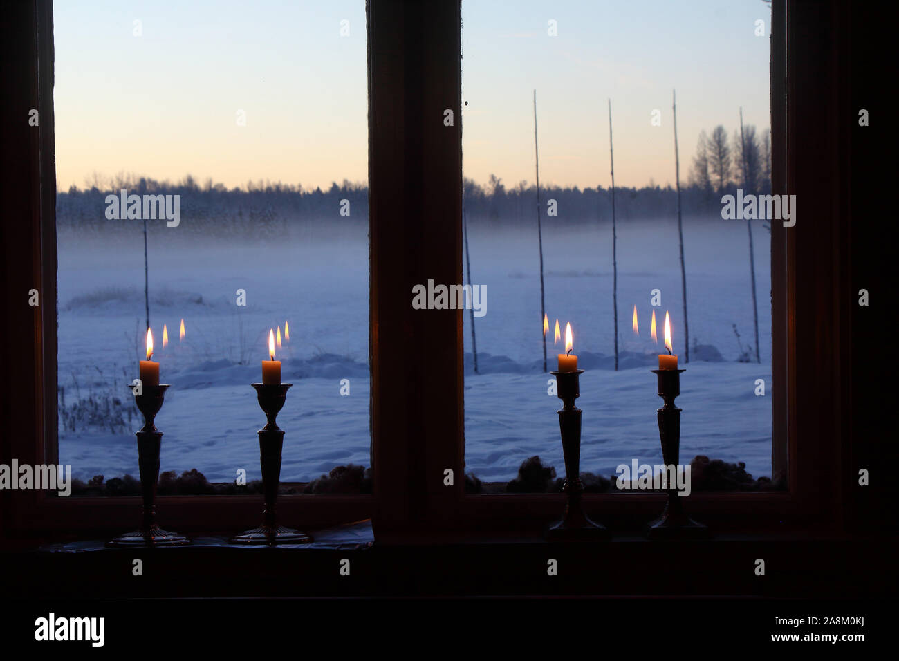 Quatre bougies dans une vieille fenêtre traditionnelle. L'extérieur est un paysage d'hiver, ciel bleu et soleil. La laine de mouton est utilisée comme décoration extérieure entre une Banque D'Images