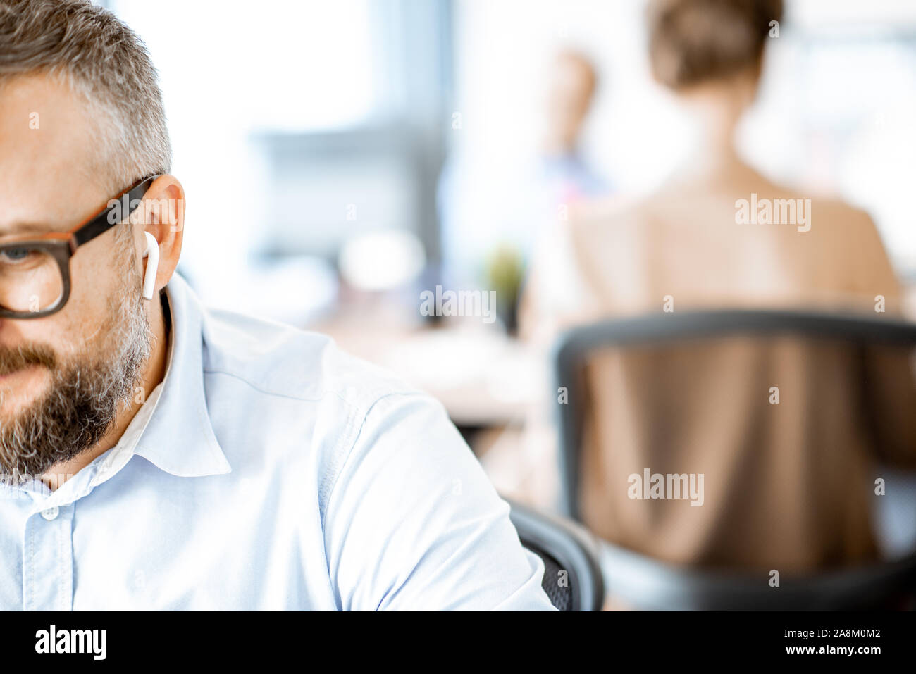 Écouteurs sans fil avec l'homme dans le bureau, close-up a porté sur la face coupée et écouteurs Banque D'Images