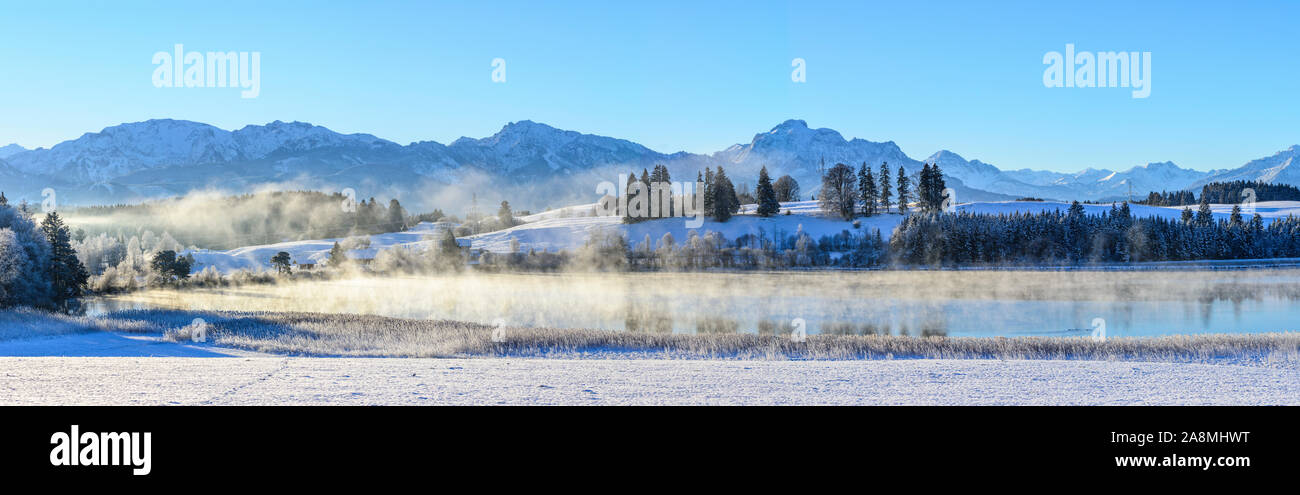 Première neige dans les contreforts des Alpes près d'un petit étang dans bavariain la lumière tôt le matin avec un ciel clair Banque D'Images