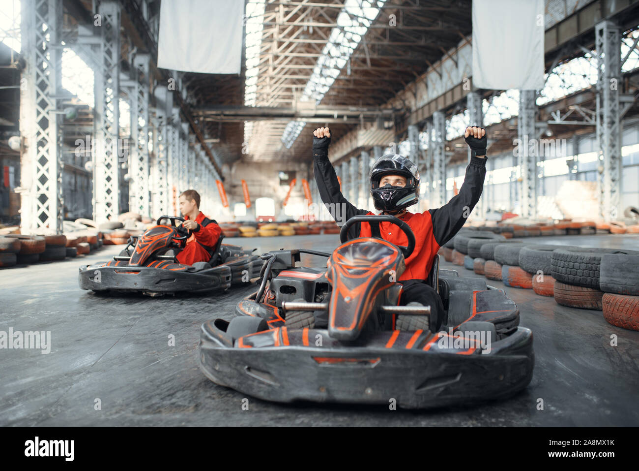 Go Kart racer leva les mains vers le haut, vue avant Banque D'Images
