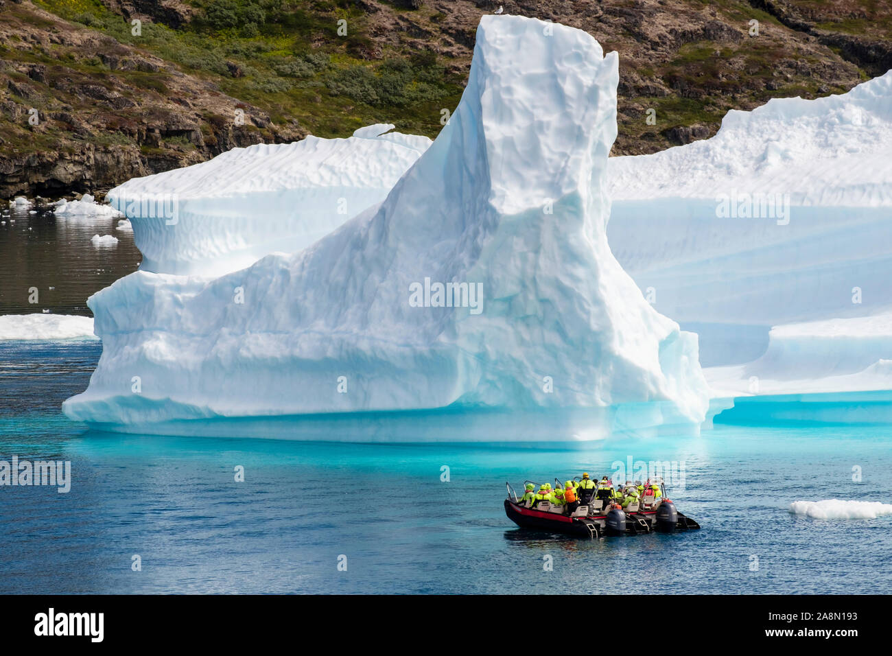 Les touristes dans de petits bateaux à voile à proximité de grands Icebergs de fjord Tunulliarfik en été. Narsaq Kujalleq, le sud du Groenland, Banque D'Images