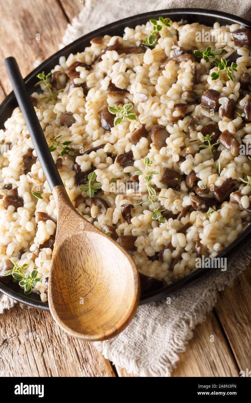 Orzotto sain aux cèpes et le thym libre sur une plaque sur la table verticale. Banque D'Images