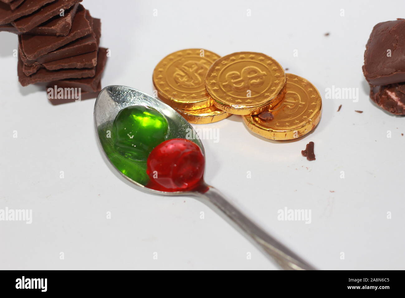 Kids propose de jelly chocolat sur une cuillère et chocolats d'or Banque D'Images