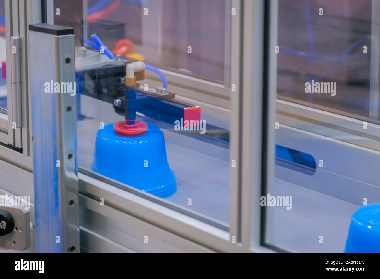 Casseroles sur la courroie du convoyeur de machine de moulage par injection en plastique avec bras robotisé Banque D'Images