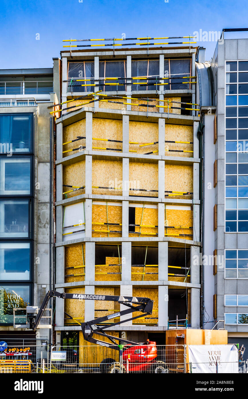 Bâtiment moderne d'être converti avec l'aggloméré dans fenêtre espaces comme protection contre les intempéries - Anvers, Belgique. Banque D'Images