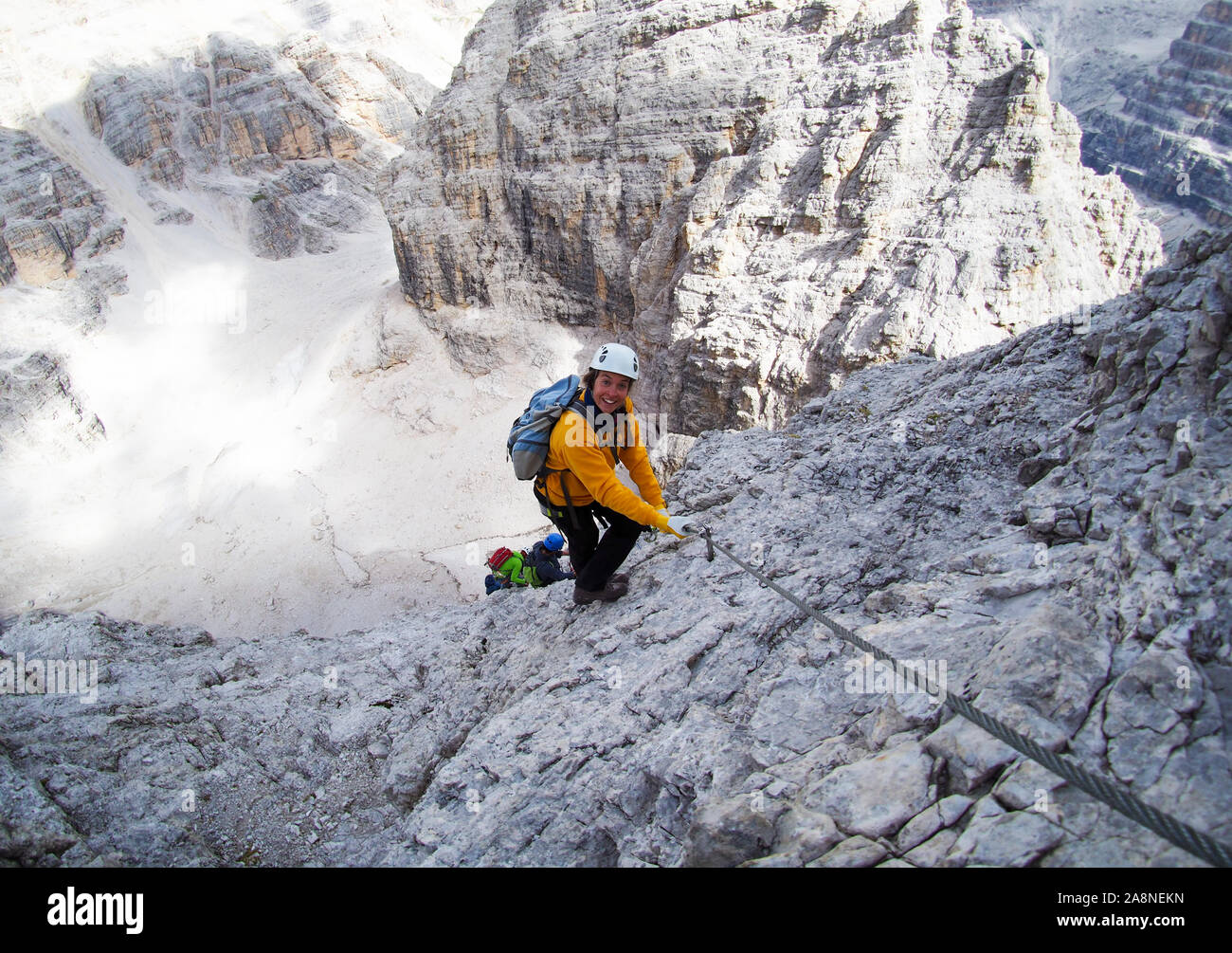 Attractive brunette female climber sur une pente raide et exposé via ferrata dans les Dolomites Banque D'Images