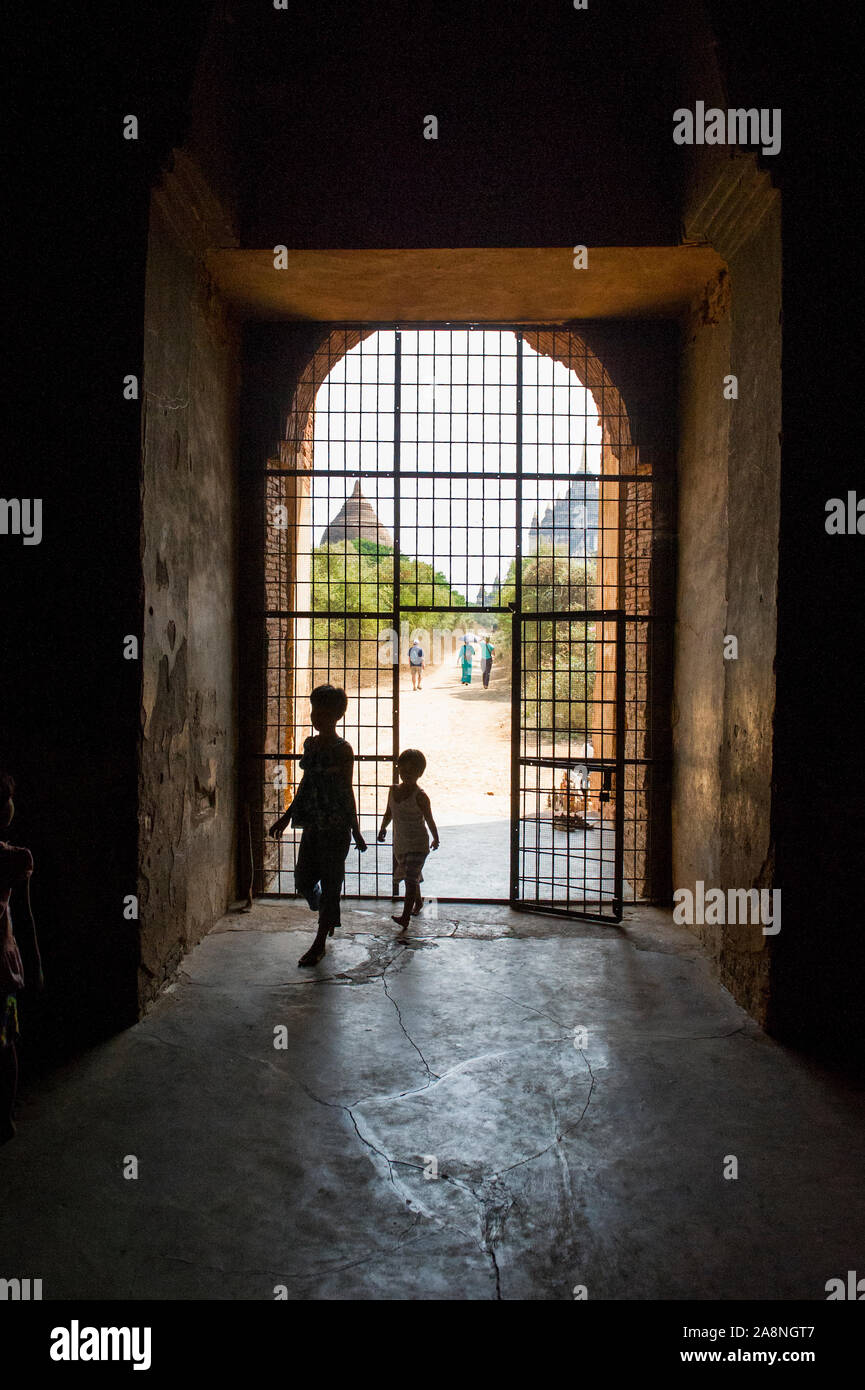 Enfants locaux entrant dans le temple Nanpaya à Bagan Myanmar, Birmanie Banque D'Images