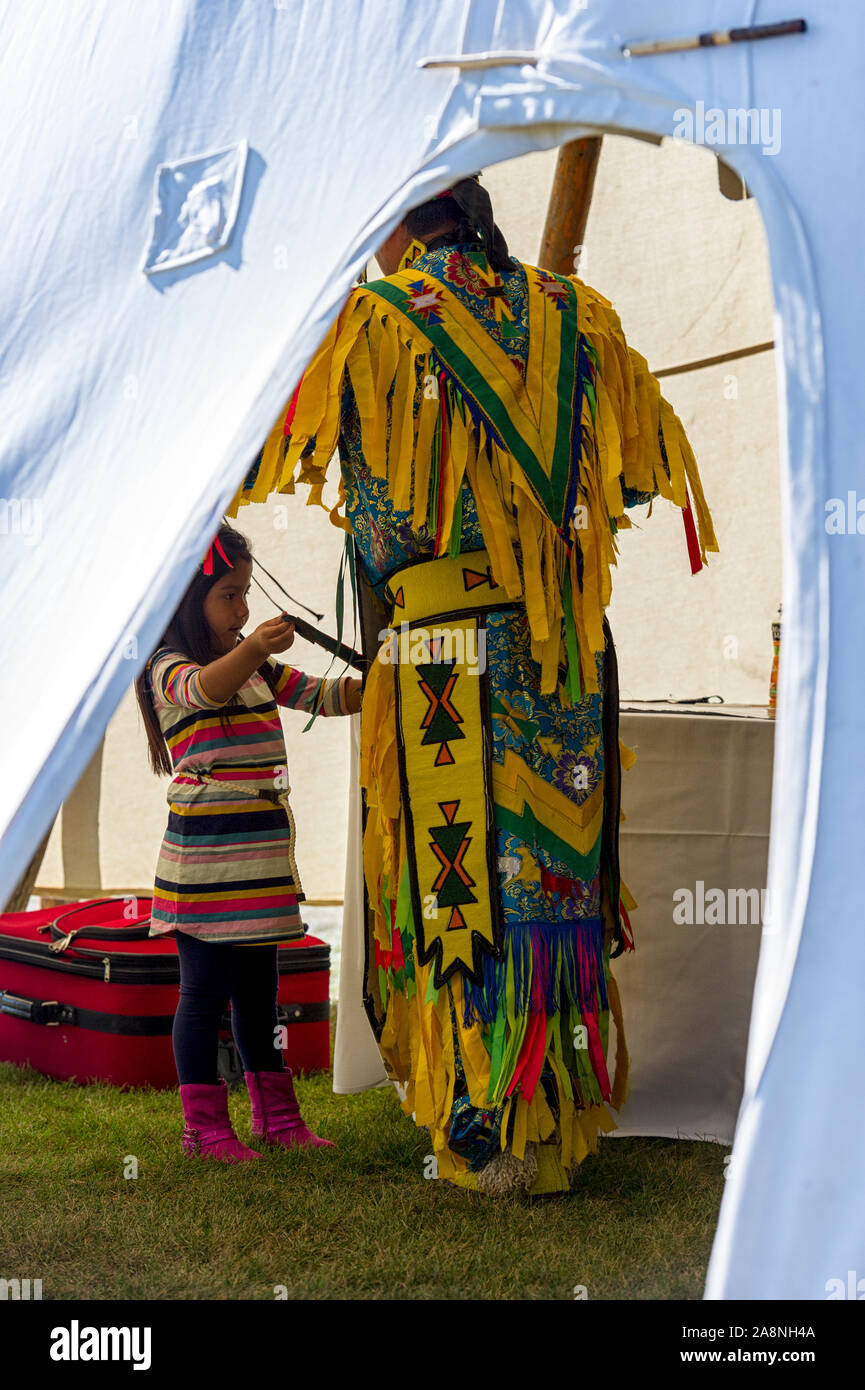 Aider un enfant autochtone à son costume danseuse adultes Banque D'Images