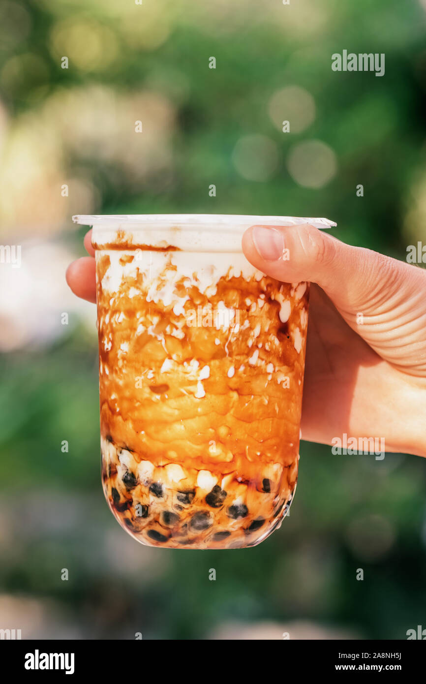 Lait glacé femme hand holding bubble tea avec perles de tapioca et de caramel Banque D'Images