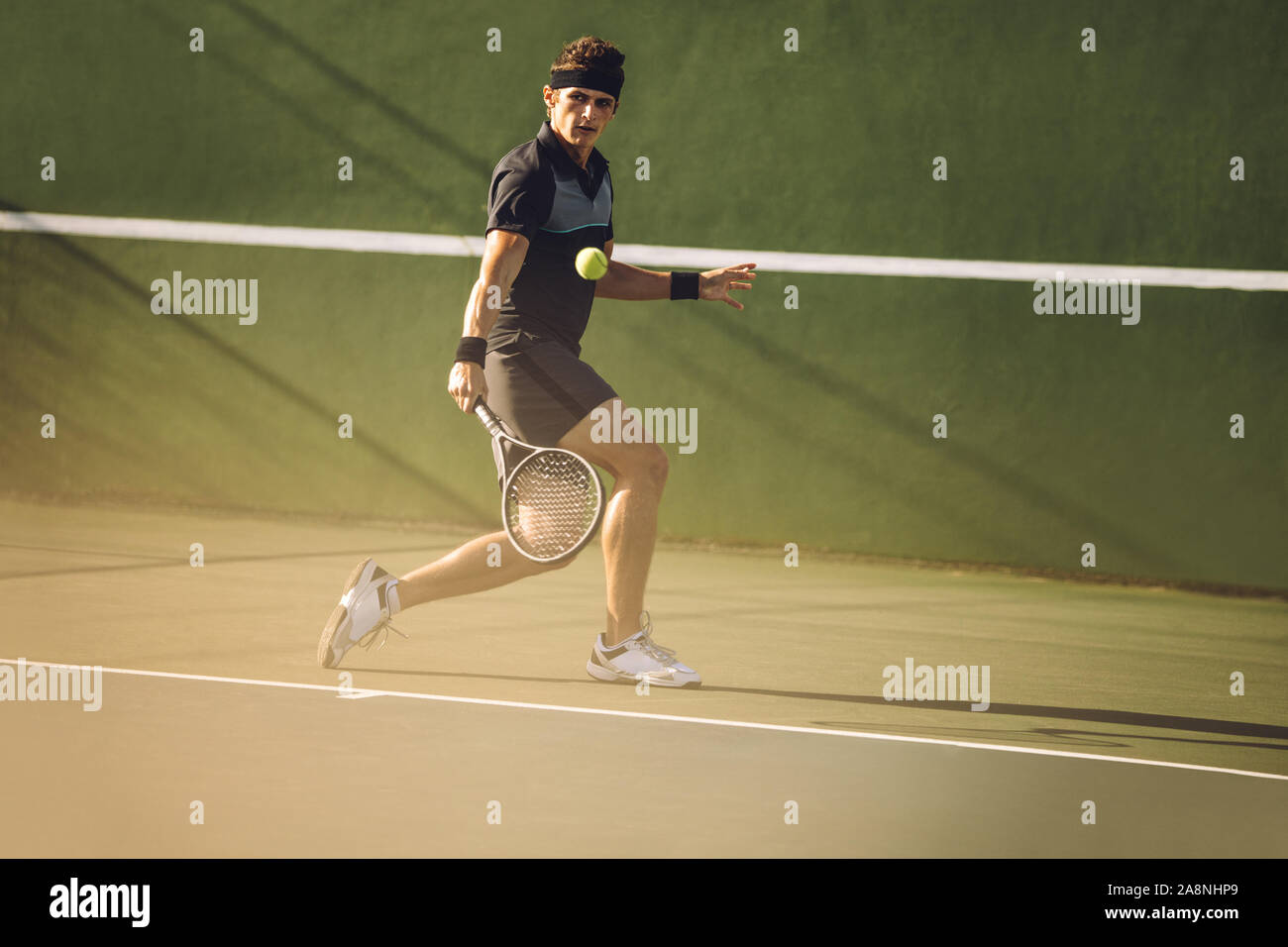 Joueur de tennis professionnel frapper un revers solide pendant un match. Tennis player jouant sur une surface dure. Banque D'Images