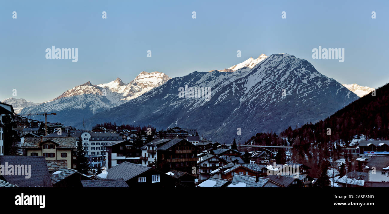 Hôtels traditionnels en bois et des huttes à Saas-Fee Ski Resort avec la lumière du matin sur chaîne de montagne en Suisse Banque D'Images