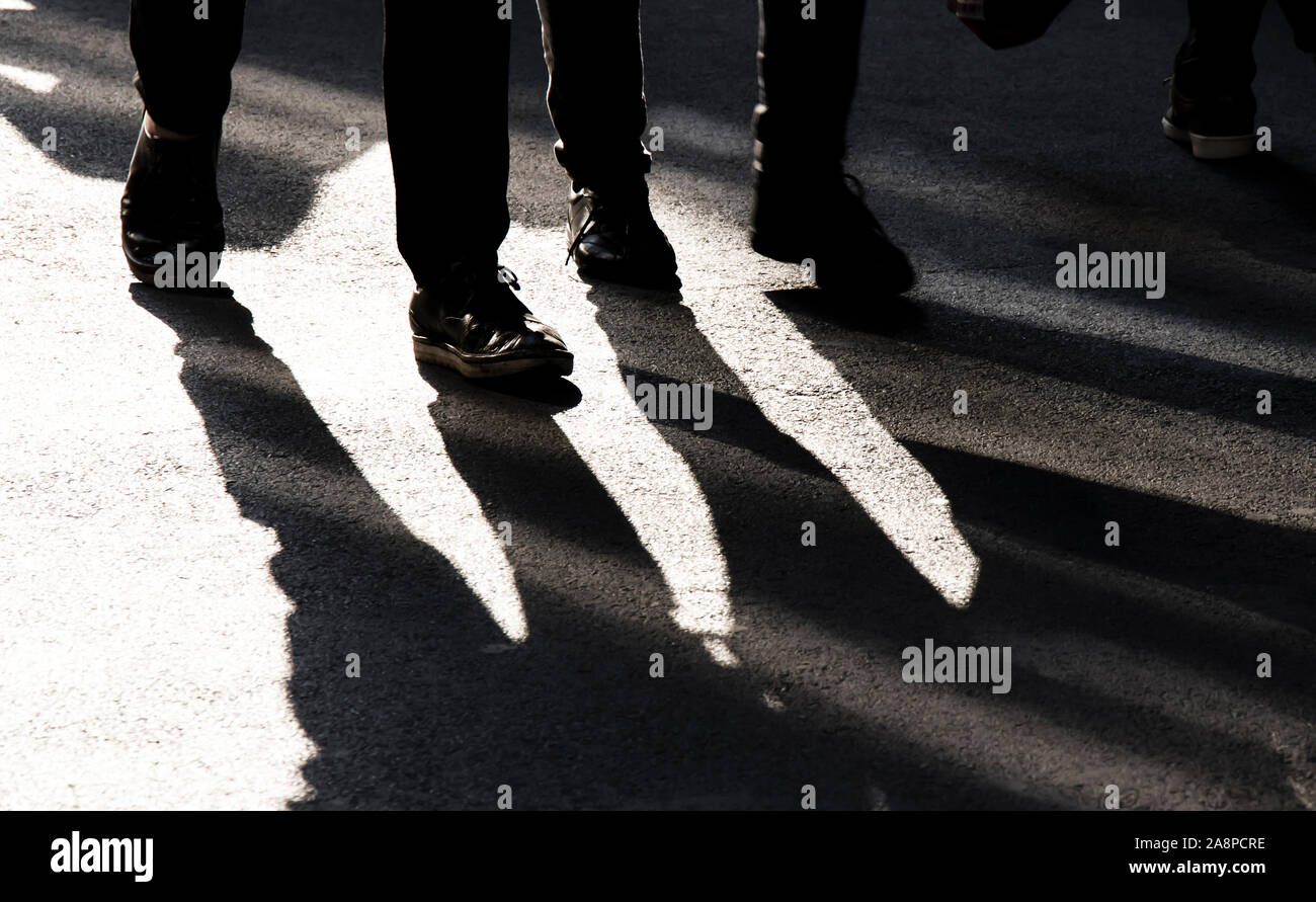 Silhouette d'ombre floue de deux personnes marchant sur la rue piétonne de la ville en noir et blanc à contraste élevé Banque D'Images