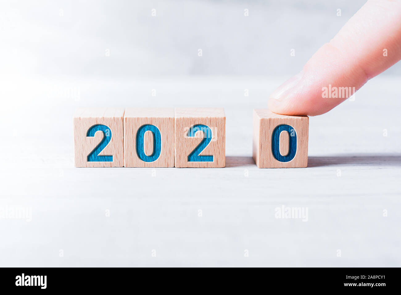 L'année 2020 formé par des blocs de bois et il est composé par un doigt sur un tableau blanc Banque D'Images