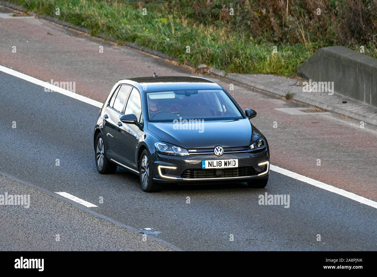 2018 gris VW Volkswagen E-Golf ; circulation automobile au Royaume-Uni, transport, véhicules modernes, voitures de berline, véhicules électriques, berline électrique premium, véhicules électriques, moteur électrique, véhicule électrique, véhicule électrique, propriété de voiture électrique, direction sud sur l'autoroute M6 à 3 voies. Banque D'Images