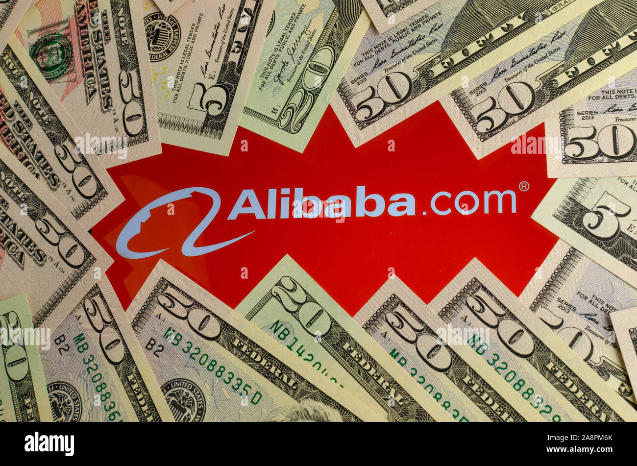 Alibaba logo sur un écran entouré de billets en dollars. Pour la photo conceptuelle nouvelles à propos de record de chiffre d'Alibaba. Banque D'Images